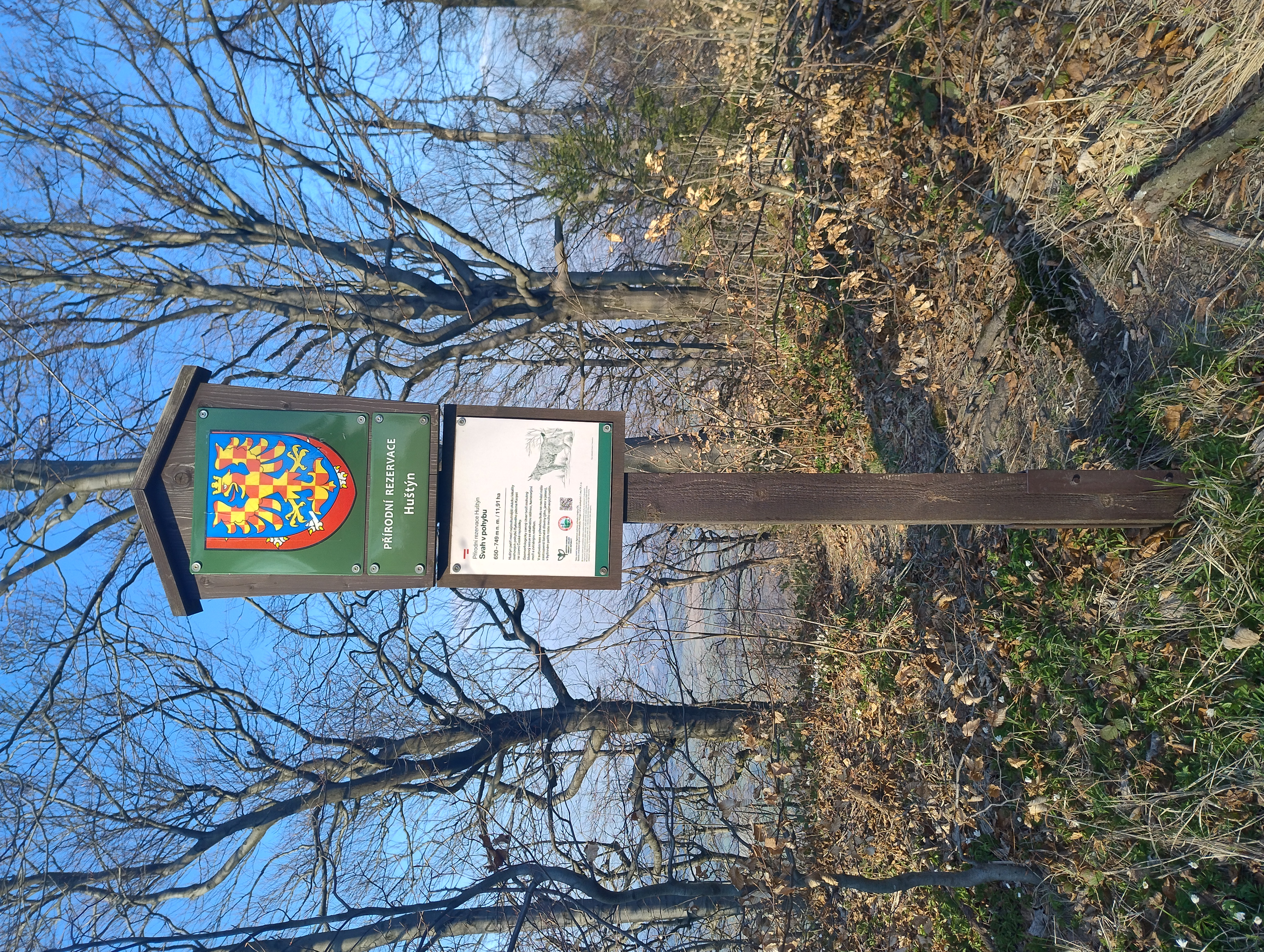 hraničník PR Huštýn s malým státním znakem přelepeným moravskou orlicí 